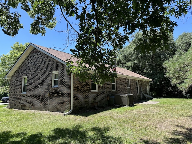 view of property exterior with a lawn and central AC