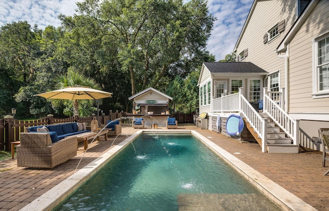 view of swimming pool with pool water feature, a patio, an outdoor hangout area, and an outdoor structure