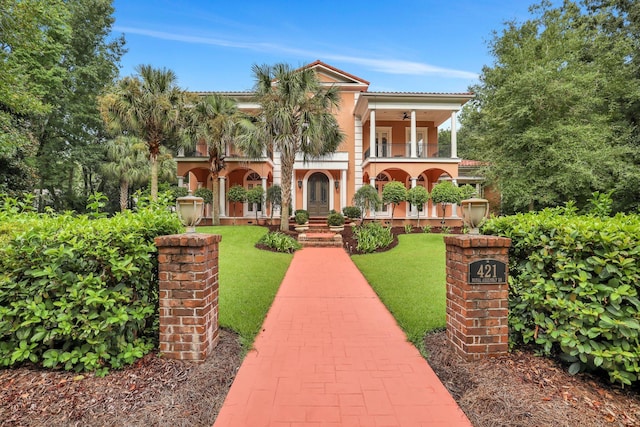 view of front of home with a porch, a front lawn, and a balcony