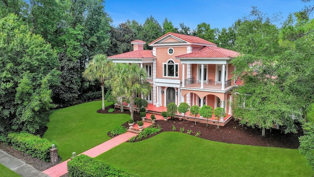 mediterranean / spanish house featuring a front lawn and a balcony