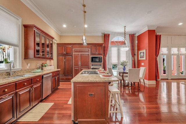 kitchen featuring built in appliances, a healthy amount of sunlight, a kitchen island, and a notable chandelier