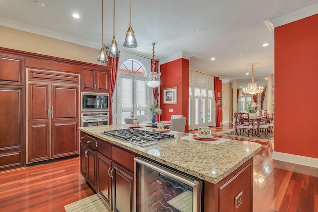 kitchen featuring built in appliances, wine cooler, an inviting chandelier, wood-type flooring, and a center island