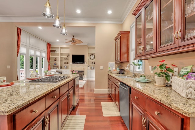 kitchen with a fireplace, hardwood / wood-style floors, stainless steel appliances, sink, and ceiling fan