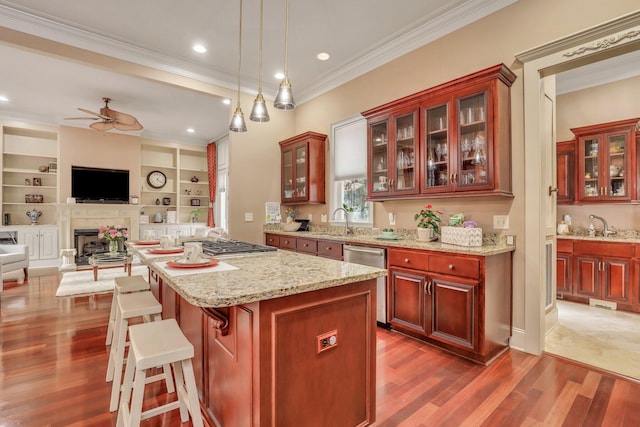 kitchen with built in features, dark wood-type flooring, ceiling fan, and a kitchen breakfast bar