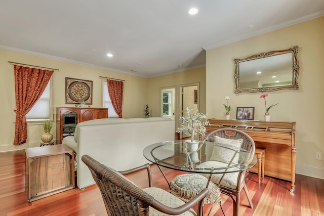 dining space with wood-type flooring and ornamental molding