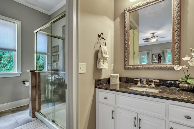 bathroom with vanity, a shower with shower door, ornamental molding, tile patterned floors, and ceiling fan