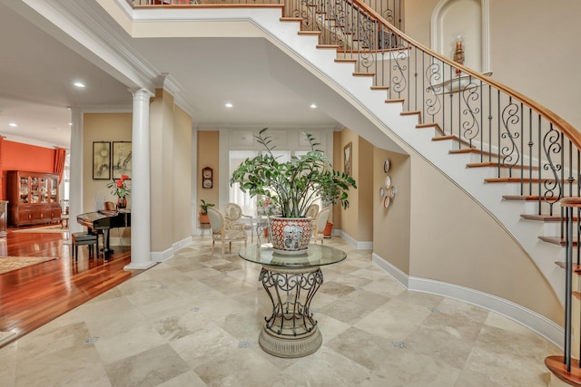 entrance foyer with decorative columns, hardwood / wood-style flooring, and crown molding