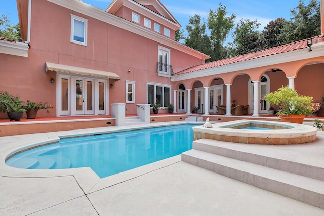 view of pool with a patio area, an in ground hot tub, and french doors