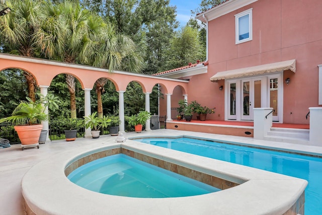 view of swimming pool with an in ground hot tub and french doors