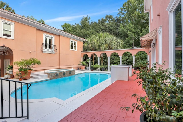 view of pool with a patio and an in ground hot tub