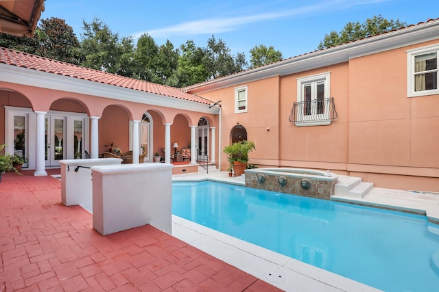 view of pool featuring a patio, an in ground hot tub, and french doors