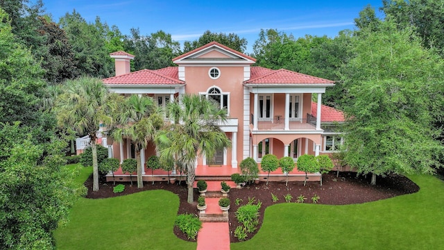 view of front of house featuring a balcony and a front lawn