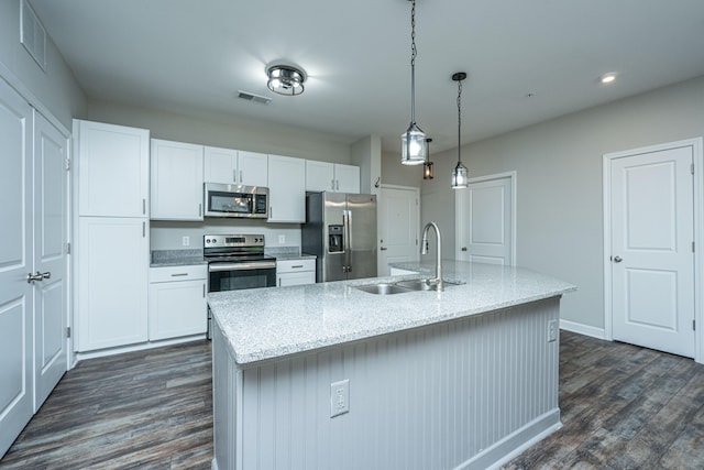 kitchen featuring dark hardwood / wood-style floors, sink, an island with sink, and appliances with stainless steel finishes