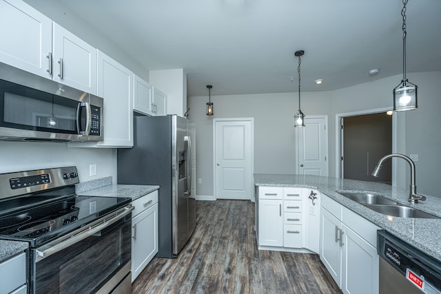 kitchen featuring pendant lighting, dark wood-type flooring, white cabinets, sink, and appliances with stainless steel finishes