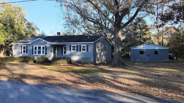 ranch-style house with an outbuilding and a front yard