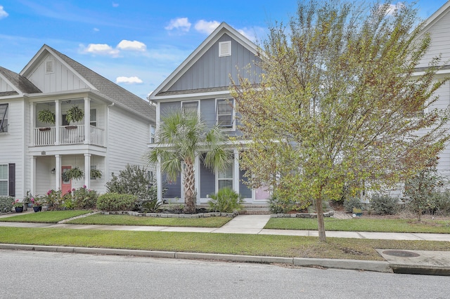 view of front of property with a front yard and a balcony