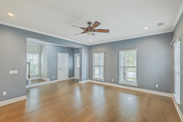 empty room with ornamental molding, wood-type flooring, and ceiling fan