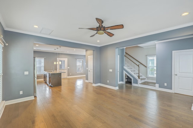 unfurnished living room with light hardwood / wood-style floors, ceiling fan, sink, and crown molding