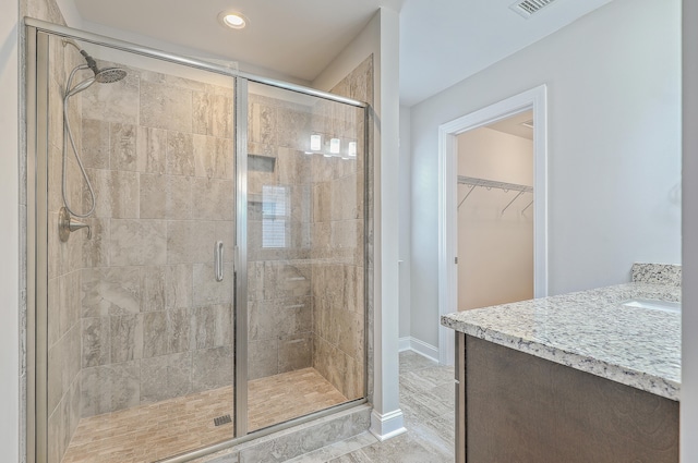 bathroom with a shower with shower door and vanity