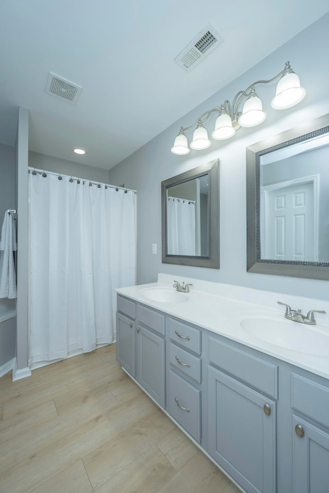 bathroom with vanity, walk in shower, and hardwood / wood-style floors