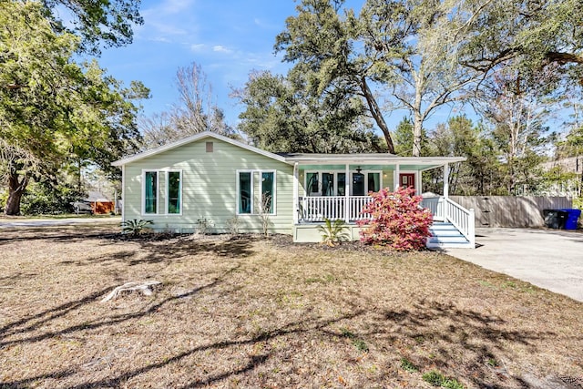 ranch-style home featuring fence and covered porch