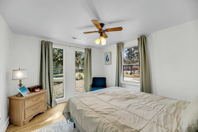 bedroom with visible vents, multiple windows, light wood-type flooring, and ceiling fan