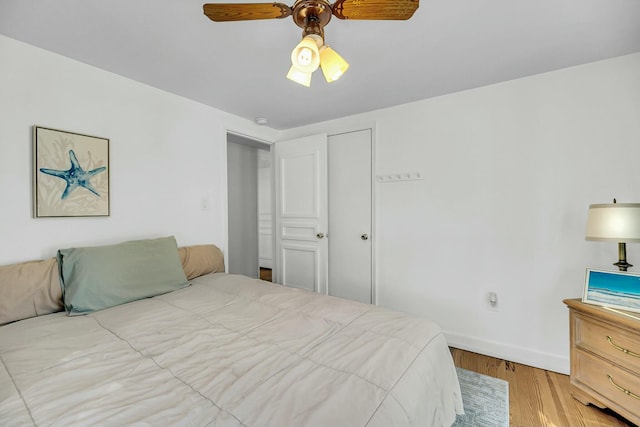 bedroom featuring wood finished floors, baseboards, a closet, and ceiling fan