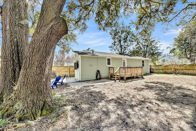 back of property featuring a deck and a fenced backyard