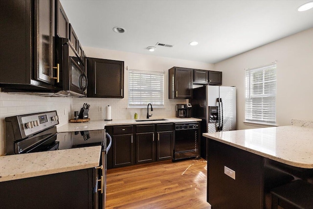 312 Kelsey Blvd, Wando, SC 29492 - kitchen featuring black appliances, plenty of natural light, light wood-style flooring, decorative backsplash, and recessed lighting