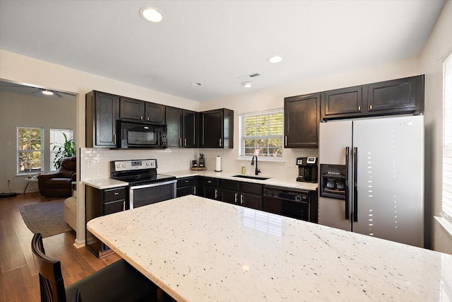 312 Kelsey Blvd, Wando, SC 29492 - kitchen featuring black appliances, plenty of natural light, wood finished floors, decorative backsplash, and recessed lighting
