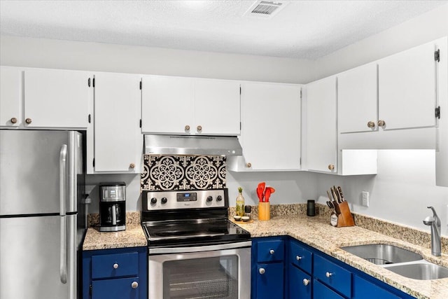 kitchen with blue cabinetry, under cabinet range hood, visible vents, a sink, and appliances with stainless steel finishes