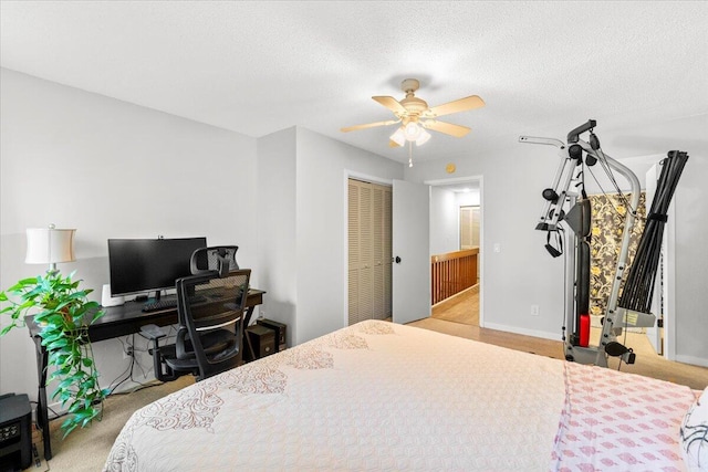 bedroom featuring carpet, a textured ceiling, baseboards, and ceiling fan