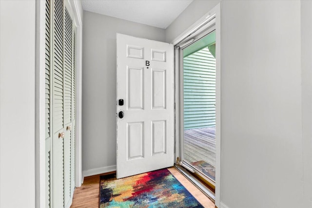 foyer featuring light wood-style flooring and baseboards