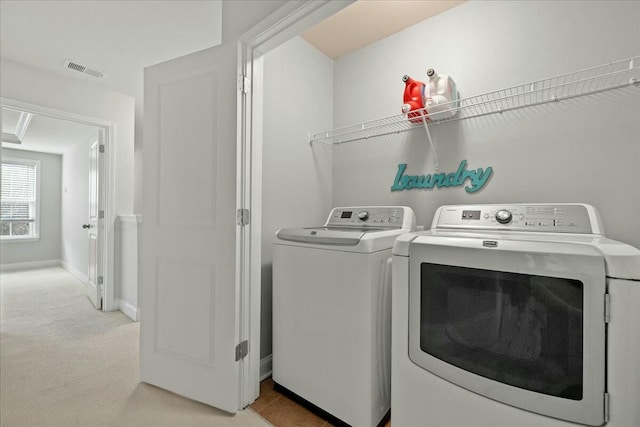 laundry area with light colored carpet and washer and clothes dryer