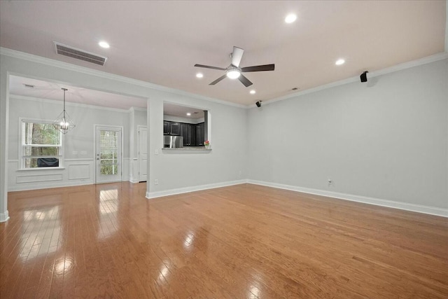 unfurnished living room featuring ceiling fan with notable chandelier, ornamental molding, and light hardwood / wood-style floors