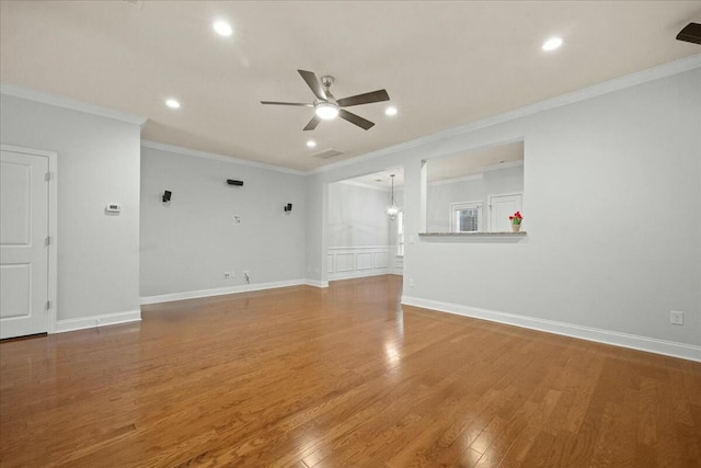 unfurnished living room featuring hardwood / wood-style floors, ornamental molding, and ceiling fan