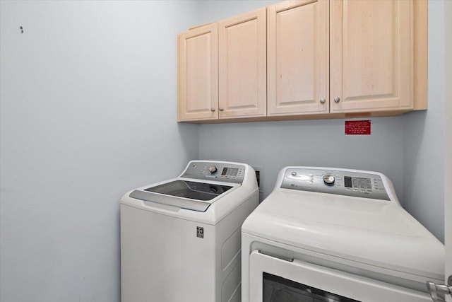 laundry room featuring cabinets and washer and clothes dryer