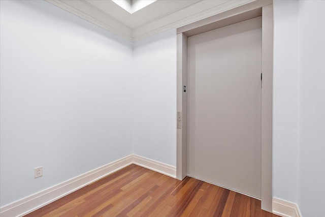 spare room with hardwood / wood-style floors and elevator