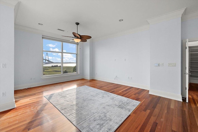 empty room featuring ceiling fan, wood-type flooring, and ornamental molding