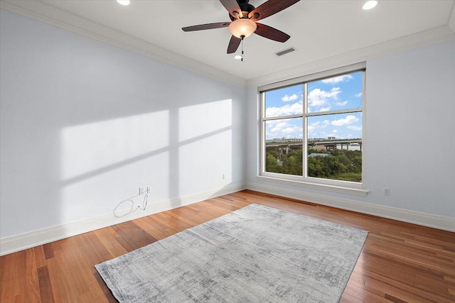 unfurnished room featuring hardwood / wood-style floors, a healthy amount of sunlight, and ornamental molding