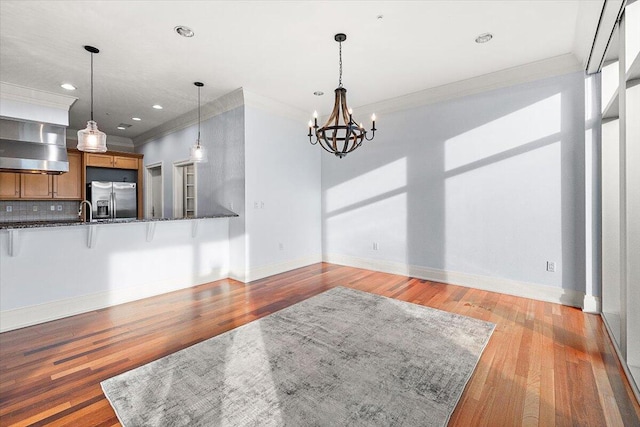 interior space featuring crown molding, light hardwood / wood-style flooring, and an inviting chandelier