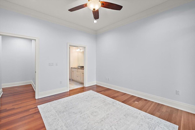 bedroom featuring ceiling fan, dark hardwood / wood-style flooring, ornamental molding, and ensuite bathroom