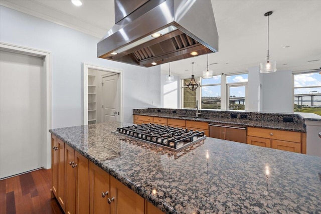 kitchen with island exhaust hood, appliances with stainless steel finishes, decorative light fixtures, and dark stone countertops