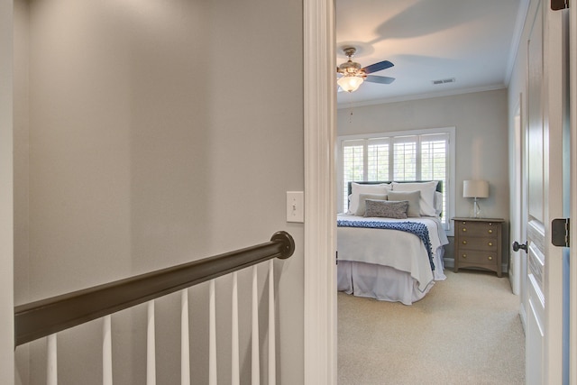 carpeted bedroom with crown molding and a ceiling fan