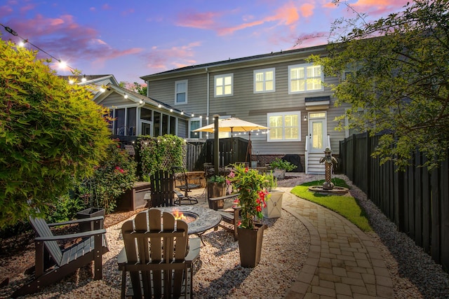 back of property featuring an outdoor fire pit, fence, a sunroom, and entry steps