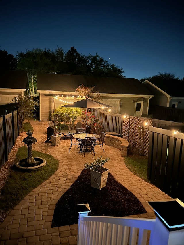 patio at twilight featuring a fenced backyard