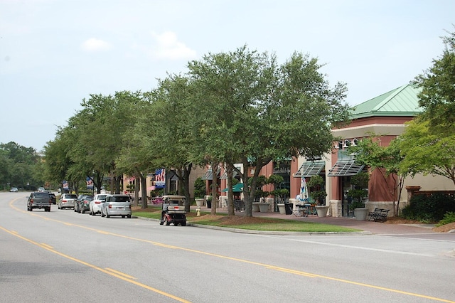 view of asphalt street featuring curbs and sidewalks
