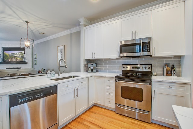 kitchen with appliances with stainless steel finishes, a sink, ornamental molding, white cabinetry, and decorative backsplash