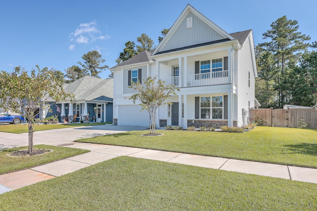 view of front facade with a balcony and a front lawn