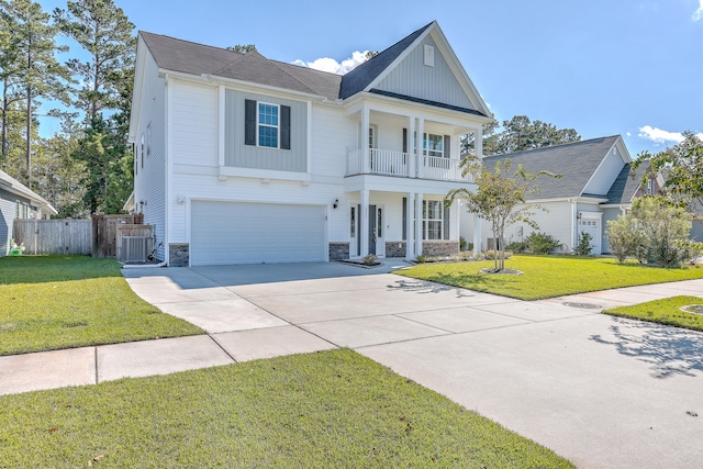 view of front of property with a front yard, a garage, a balcony, and central AC